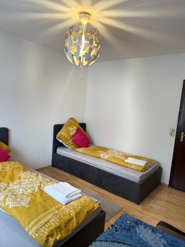 een kamer met 2 bedden en een kroonluchter bij Zimmer/Wohnung im Zentrum Kehl in Kehl am Rhein
