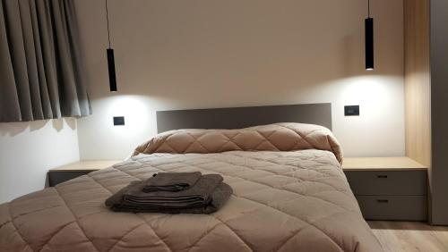 ein Schlafzimmer mit einem Bett mit einer Decke darauf in der Unterkunft fragilerooms in Dolo