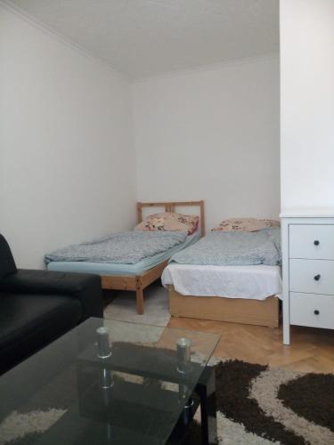 a living room with two beds and a glass table at Bibi Apartment in Martin