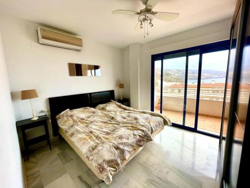 sypialnia z łóżkiem i dużym oknem w obiekcie Sunny 2-bedroom apartment with sea view w mieście Castell de Ferro