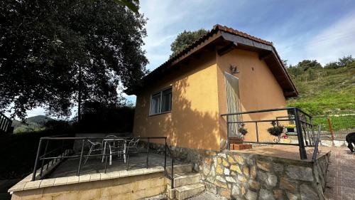 Casa pequeña con balcón y mesa en Casa mar y monte en Sanfuentes