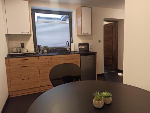 a kitchen with a black table and a counter top at Pod Domem in Grodzisk Mazowiecki