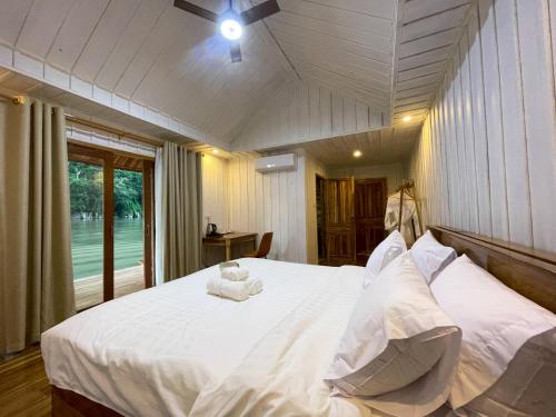 a bedroom with a large bed with white sheets and pillows at Nongkhiaw The Float House in Nongkhiaw