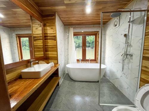 y baño con 2 lavabos, bañera y ducha. en Nongkhiaw The Float House en Nongkhiaw