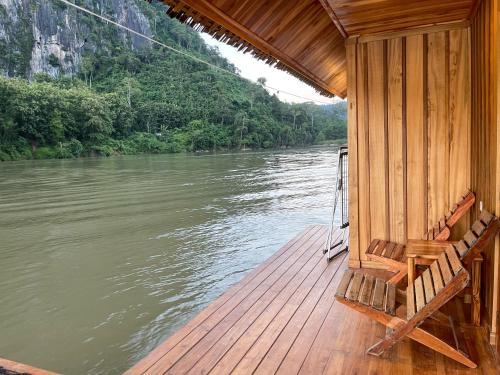 a wooden deck of a boat on a river at Nongkhiaw The Float House in Nongkhiaw