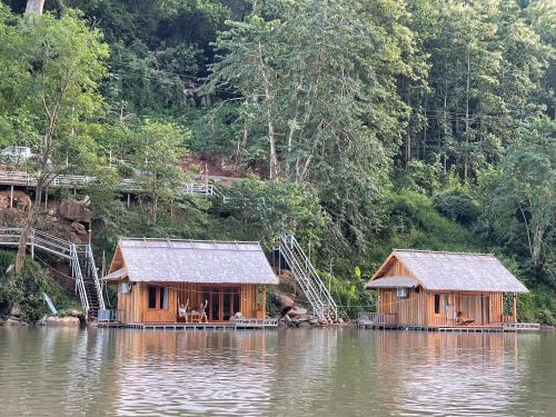 two wooden huts in the middle of a body of water at Nongkhiaw The Float House in Nongkhiaw