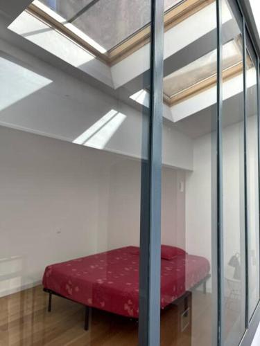 een rood bed in een kamer met een glazen wand bij Loft lumineux en centre ville in Sète