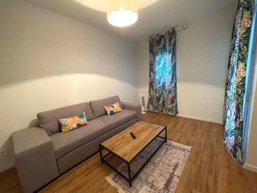 un salon avec un canapé et une table basse dans l'établissement Le Tropical - Spacieux T2 proche toutes commodités, à Annecy