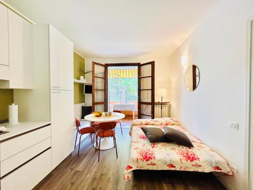 uma cozinha e uma sala de jantar com uma cama e uma mesa em Mercury Apartment - Vista Lago con Piscina em Sirmione