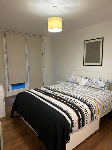 a bedroom with a bed with a black and white comforter at Urban Oasis Two-Bedroom suite complete with a distinct living area and kitchenette in Birmingham