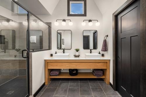 ein Badezimmer mit zwei Waschbecken und zwei Spiegeln in der Unterkunft Luxury Lakefront Villa - Over 30 FREE amenities included! in Kimberling City
