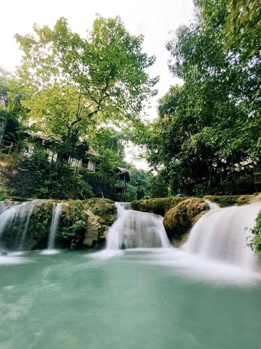 a waterfall in the middle of a river at LePont Mu Waterfall Bungalow in Hòa Bình