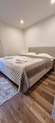 een groot bed in een slaapkamer met een houten vloer bij Stenhuset in Linköping