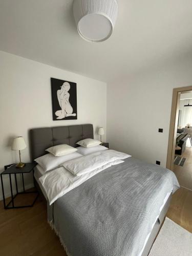 biała sypialnia z dużym łóżkiem i lampką w obiekcie Apartman V u centru Kutine w mieście Kutina