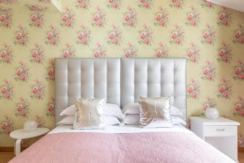 - une chambre avec un grand lit blanc et un couvre-lit rose dans l'établissement T-House Fontana di Trevi, à Rome