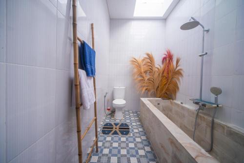 a bathroom with a tub and a toilet in it at Cheerful Private 1Br HoneyMoon Villa BlueLove Seririt in Banjar