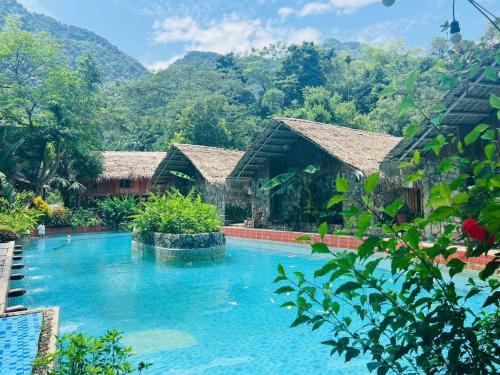 uma piscina de resort com montanhas ao fundo em LePont Mu Waterfall Bungalow em Hòa Bình