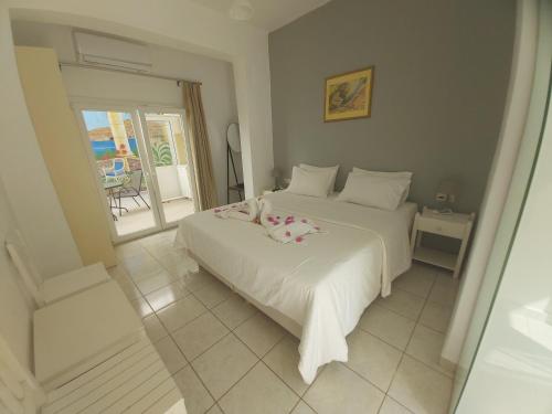 a bedroom with a white bed and a balcony at Antonios 1 in Matala