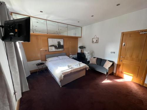 1 dormitorio con cama, sofá y TV en Camden, London, Holloway Rooms 20 Busby Place, NW5 2SR, en Londres