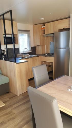 Il comprend une cuisine équipée d'un réfrigérateur, d'une table et de chaises. dans l'établissement Chez Loulou F77, à Saint-Jean-de-Monts