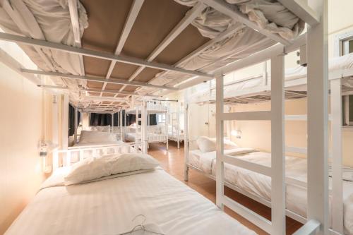 two bunk beds in a room with white beds at Beds Friends Phi Phi Hostel in Phi Phi Islands