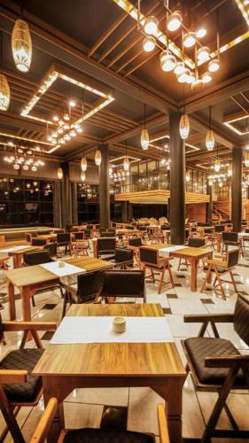a restaurant with wooden tables and chairs and lights at Covanro Sigiriya - Where Heritage Meets Luxury in Sigiriya