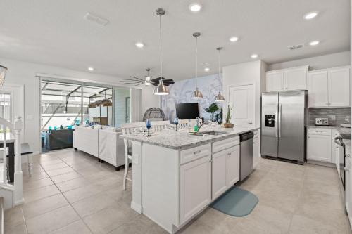 a kitchen with white cabinets and a large kitchen island at NEW to Market New Construction 5 Bed Retreat In World Famous Windsor Island in Davenport