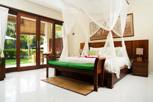 a bedroom with a bed with a canopy at Ubud Tropical Garden in Ubud