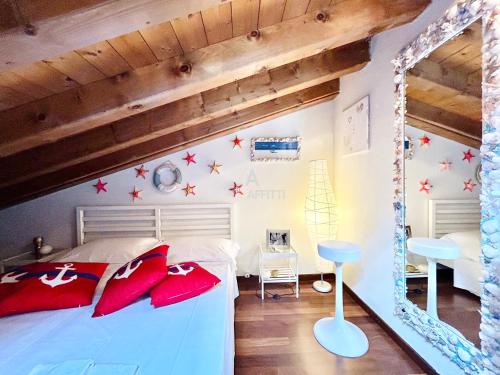 um quarto com uma cama branca e almofadas vermelhas em Rea Apartment - 500 m dal Lago con Piscina em Sirmione