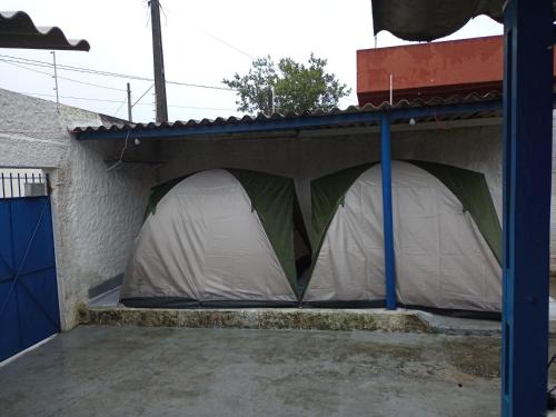 a tent is set up on the side of a house at Hostel Pé na praia - Quartos e Barracas Camping in Caraguatatuba