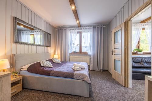 a bedroom with a bed and a mirror at Apartament u Majerczyka in Zakopane