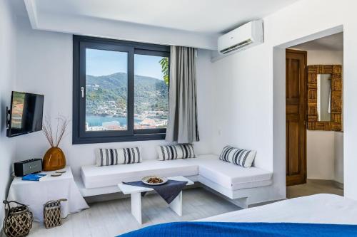 a living room with a white couch and a window at To Nissi in Skopelos Town