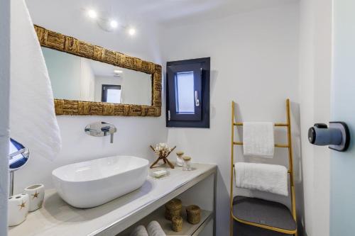 a bathroom with a white sink and a mirror at To Nissi in Skopelos Town