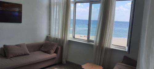 - un salon avec un canapé et une vue sur l'océan dans l'établissement DENİZ YILDIZI, à Marmaraereglisi