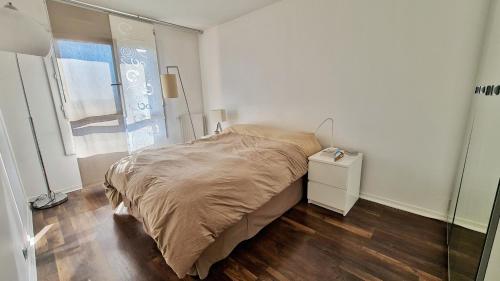 um pequeno quarto com uma cama e uma janela em Cosy flat 60m2 - beautiful large rooftop - near metro and train station - free secure car parking em Paris
