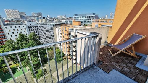 une chaise sur un balcon avec vue sur la ville dans l'établissement Cosy flat 60m2 - beautiful large rooftop - near metro and train station - free secure car parking, à Paris