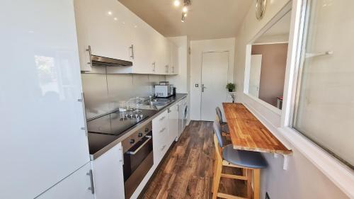 A kitchen or kitchenette at Cosy flat 60m2 - beautiful large rooftop - near metro and train station - free secure car parking