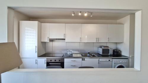 A kitchen or kitchenette at Cosy flat 60m2 - beautiful large rooftop - near metro and train station - free secure car parking