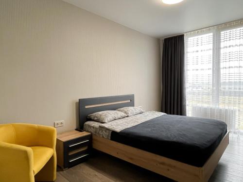 um quarto com uma cama, uma cadeira e uma janela em 093 ЖК Щасливий нові апартаменти біля Кільцевоі em Kiev