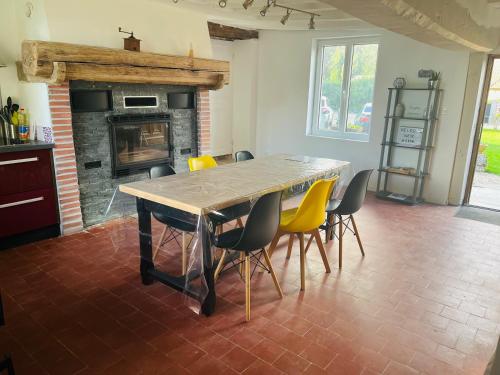 a dining room with a table and chairs and a fireplace at Maison en Colombage in Tilly