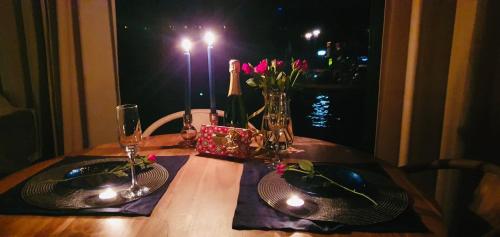 a wooden table with two plates and glasses on it at Pokój z widokiem na jezioro in Pluski