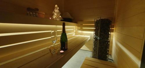 a bottle of wine and two glasses in a sauna at Pokój z widokiem na jezioro in Pluski