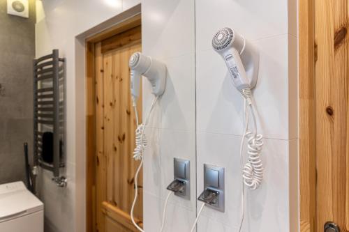 a bathroom with two hair dryers on the wall at Domki U MAJERCZYKA in Zakopane