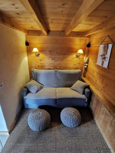 a living room with a couch and two ottomans at Petit chalet individuel de caractère in Megève