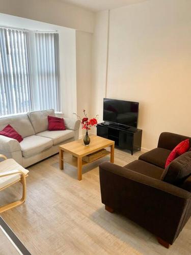 a living room with a couch and a tv at Eden Stay 5 Bedroom House in Morecambe