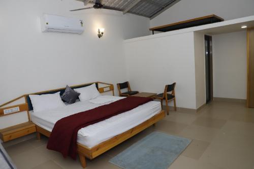 GarudeshwarにあるSomnath innのベッドルーム1室(大型ベッド1台、白いシーツ、枕付)