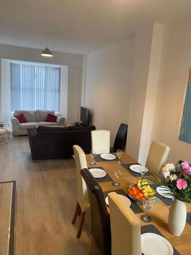 a dining room with a table and a living room at Eden Stay 5 Bedroom House in Morecambe