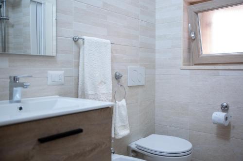 a bathroom with a sink and a toilet and a window at Da Zia Maria in Ferrandina