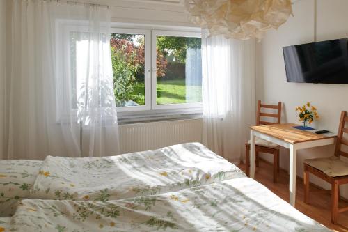 Schlafzimmer mit einem Bett, einem Tisch und einem Fenster in der Unterkunft Raumpause in Wegberg