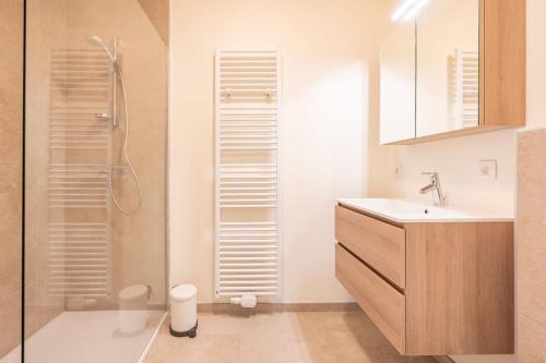 een badkamer met een douche, een wastafel en een toilet bij Sailorshouse in Nieuwpoort